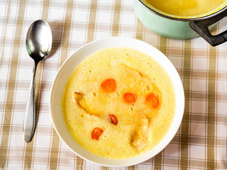 Vegetable soup from celery and carrot on plate, pot.