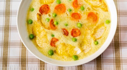 Vegetable soup from celery and carrot with green pea, closeup.