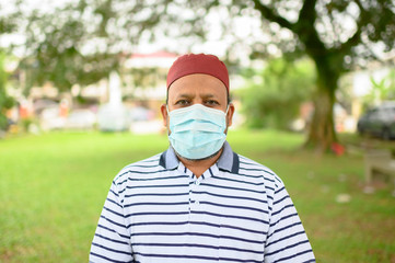Senior Asian Muslim Man in medical mask, looking at camera Health care and medical concept.