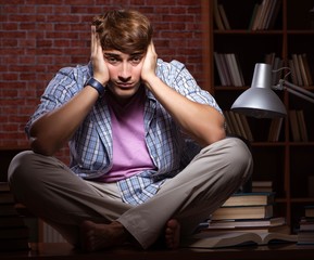 Young handsome student preparing for exams at night