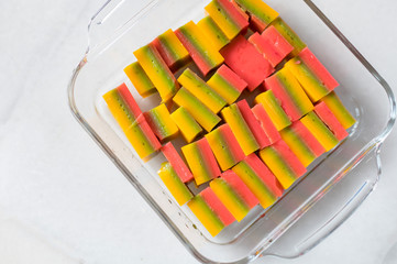 Puding marmer pelangi (Marble Rainbow Pudding) is made of agar, sugar, milk and food coloring. On transparent plate , Copy space