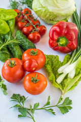 different types of vegetables on a white background top view. vegan products. peppers, cabbage, tomatoes, cucumbers, various herbs. vegetable diet.