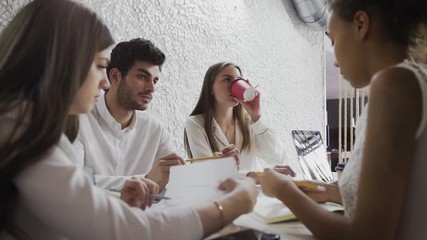 Group of diverse business executives holding a meeting around a table discussing graphs charts showing statistical data analysis - Powered by Adobe