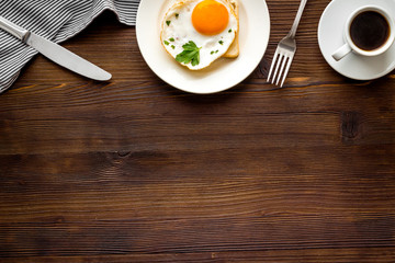 Fried eggs sandwich on plate - dark wooden desk from above space for text