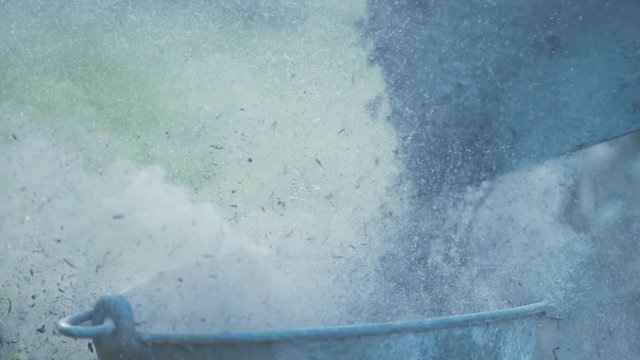 Pouring ashes from shovel into metal bucket