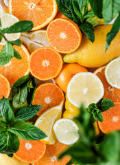 Citruses. Oranges, lemons, Limes, tangerines are scattered on the table. The sun's rays illuminate the fruit.