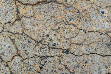 Concrete wall for backdrop. Crack on surface. Small multi-colored stones.