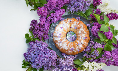Cake with purple lilac flowers. Beautiful Homemade cupcake  and a bouquet of lilacs on a purple...