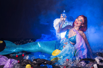 Ocean pollution, rubbish in the water. Stupid fairytale mermaid in dirty ocean. Plastic trash and garbage in water. Environmental problem, plastic bag and bottles polluting planet.