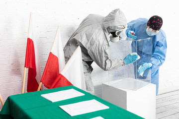 Two employees disinfect the ballot box before the presidential election in Poland.