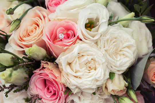 Perfect image with copy space for chic boho wedding magazines and websites, bohemian, fashion, florist. Flowers bouquet with nude roses and wedding rings. Copy space. Flowers background.