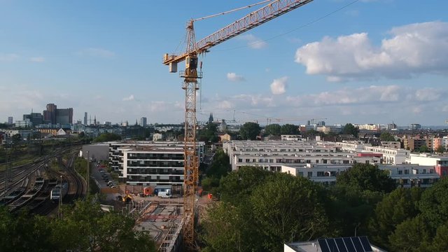 Drohnenshot Baukran auf Baustelle neben Schienenverkehr