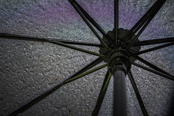 Black umbrella in the rain. View from below.