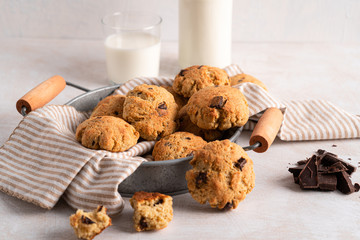 Chocolate chip cookies with milk bottles on white background