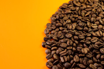 Coffee beans on a bright background. On the orange table grain of the coffee tree.