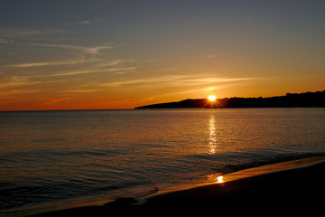 sunset by the sea with golden sun rays