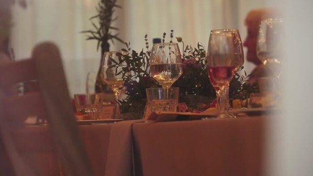 Beautiful decorated holiday table with bouquets and floral arrangements, glasses and goblets stand