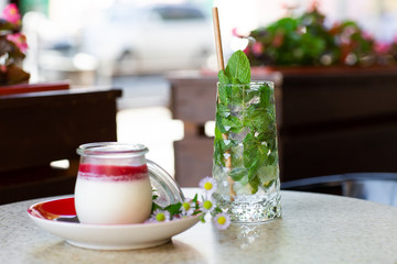 Vanilla Panna Cotta with Jelly of berries in glass jar. Italian dessert panna cotta. Classic Italian dessert creamy panna cotta with cherry sauce. Concept of pastry salon. Mojito and dessert.