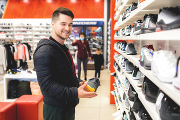 Young man looking for sports equipment at sports shop