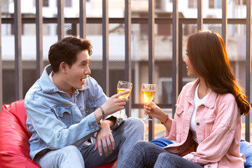 asian lover couple man and woman cheering and toast with white wine glasses to celebrating first dating in dinner party in the summertime. love, celebration, relationship and romantic concept.