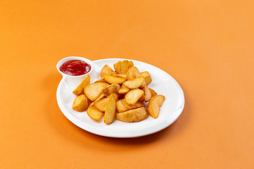 fried potato wedges in a plate on a brown background