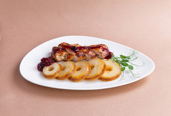 roast duck with pear in a plate. on a brown background