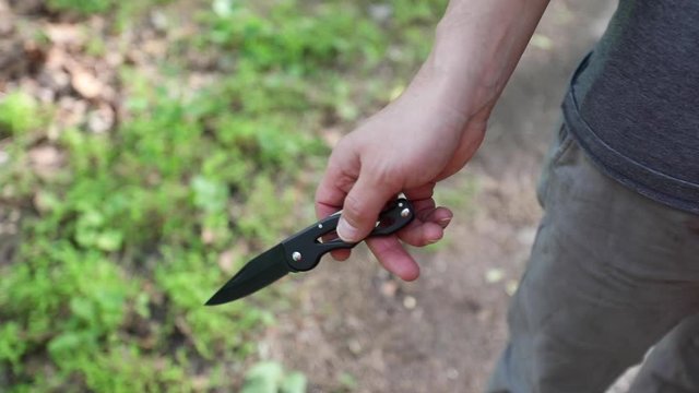 A man carries survival gear, including a pocket knife
