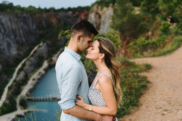 Beautiful woman and man hug and kiss near the canyon.
