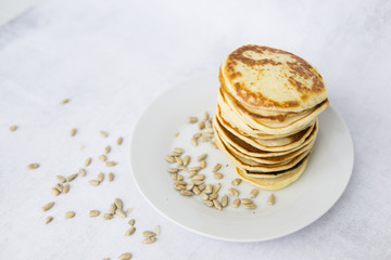 Homemade pancakes on kefir on a white plate. Cooking at home, home-cooked food. Space for text.