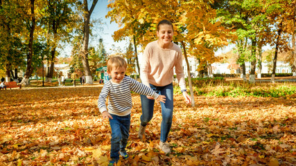 Happy laughing family running and palying at autumn park
