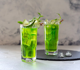 Sparkling iced lemonade with fresh mint and lime on grey background