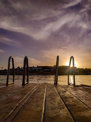 handrails for descent into the sea at sunset