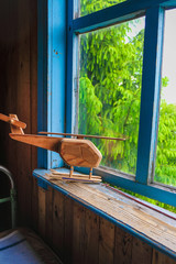 Toy wooden helicopter on the windowsill of an old wooden house in Ukraine. Flight concept. Vertical image.