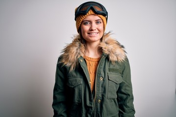 Young beautiful skier woman with blue eyes wearing snow sportswear and ski goggles with a happy and cool smile on face. Lucky person.