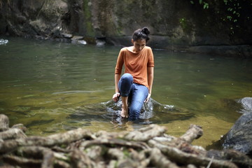 Woman sitting on a rock at a waterfall