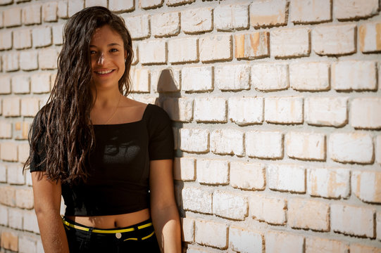 Portrait Young Woman Leaning Against Exposed Brick Wall With Space To Place Text