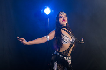 Portrait of a woman in oriental costume performing belly dance. Tribal fusion dance concept.