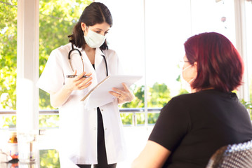 Senior patient in nursing home with assistant doctor in white uniform
