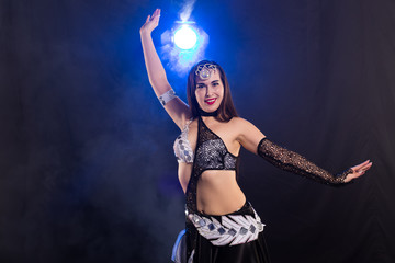 Belly dancer. Young attractive woman dancing tribal fusion on the stage. Oriental exotic dance.