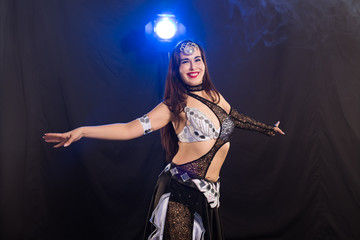 Portrait of a woman in oriental costume performing belly dance. Tribal fusion dance concept.