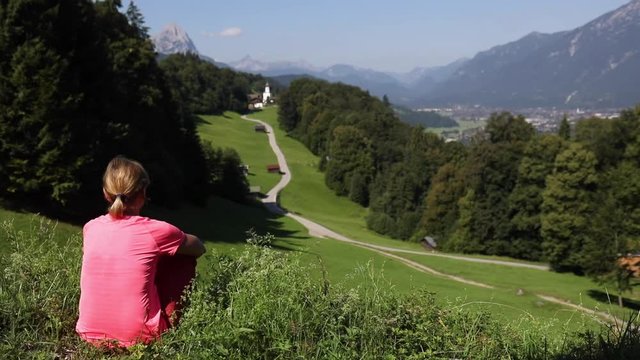 A woman admires the view of the Alps in southern Germany