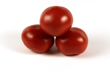 three red tomatoes isolated on a white background on top of each other