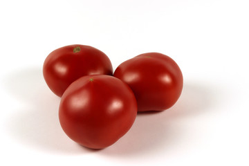 three red tomatoes isolated on a white background on top of each other