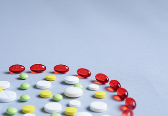 round tablets of different sizes with red vitamin capsules. Pharmaceutical concept