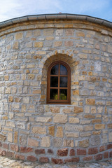 Außenansicht eines alten sanierten Gebäudes mit Sprossenfenster und Natursteinmauer