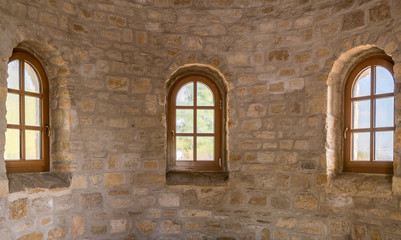 Fototapeta na wymiar Drei sanierte Sprossenfenster in einer Natursteinmauer eingefasst