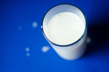 Top view glass of mils with drops on table. Copy space. International milk day. Calcium products 