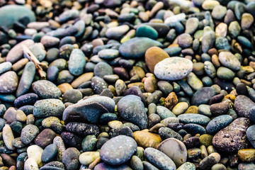 Small sea stones on the beach with different textures