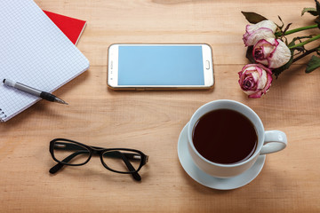 Mobile phone, glasses, cup of tea, flowers, stationery