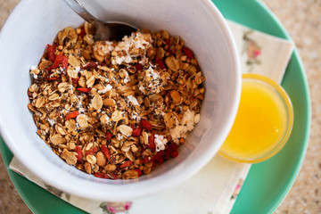 Healthy food background with homemade oatmeal granola or muesli with cottage cheese on white bowl and honey for healthy morning breakfast, top view, copy space. Breakfast and healthy concept.